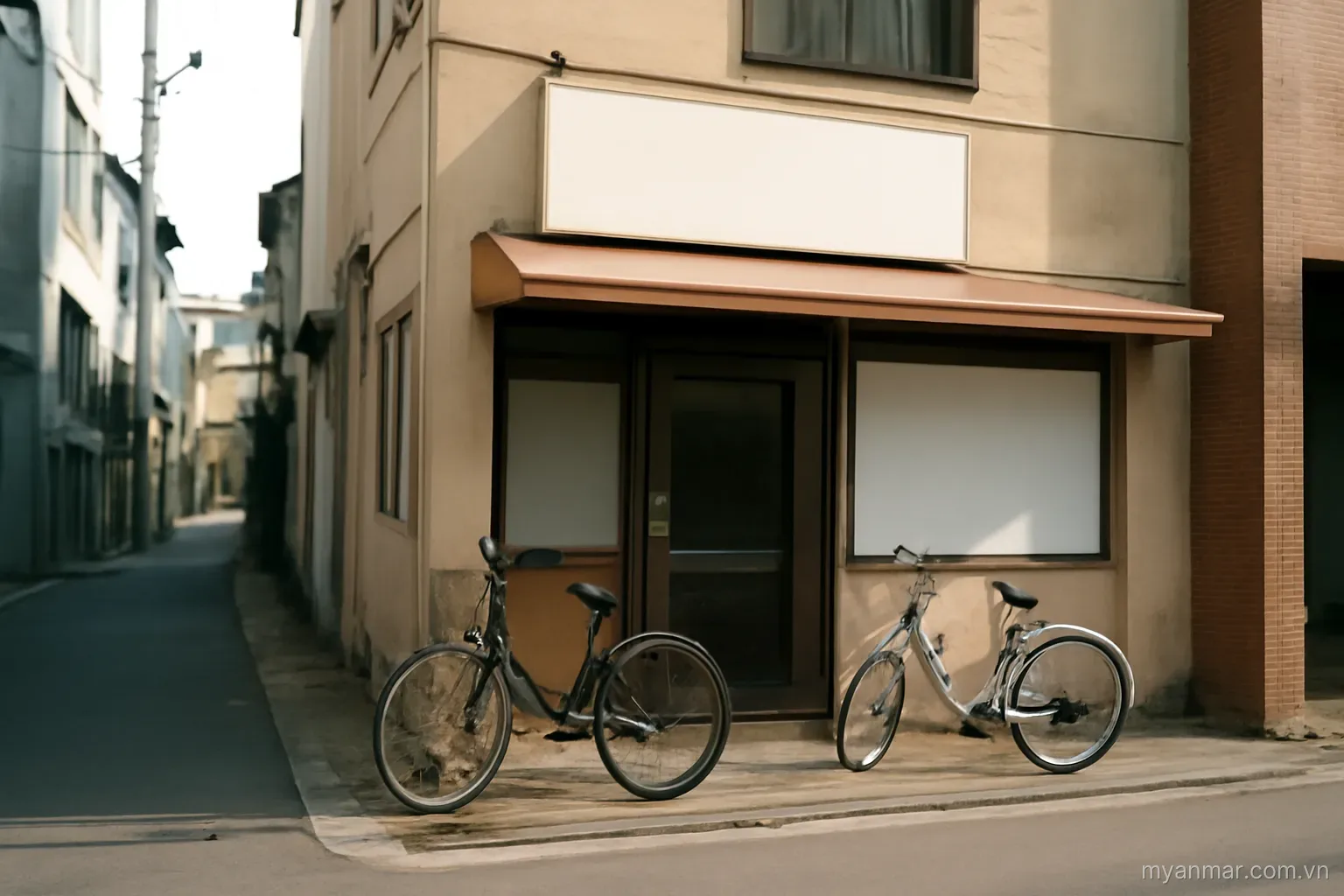 A quiet street corner with a small shop and parked bicycles in daylight, eye level, no text