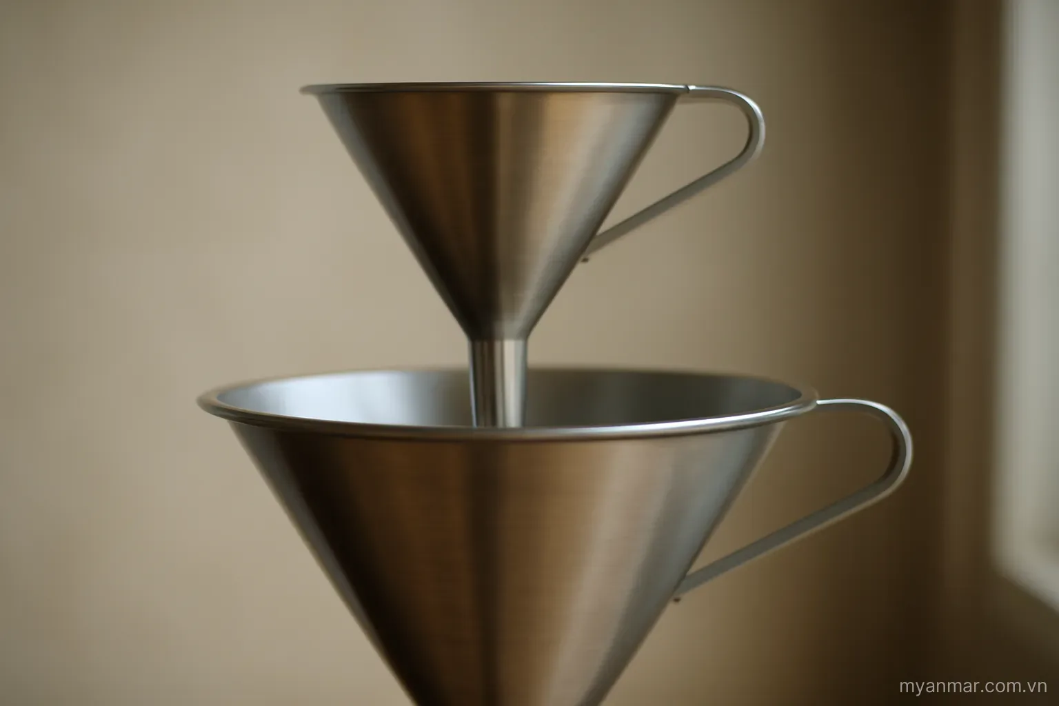 Two funnels of different sizes, the smaller one feeding into the larger, side view, no text