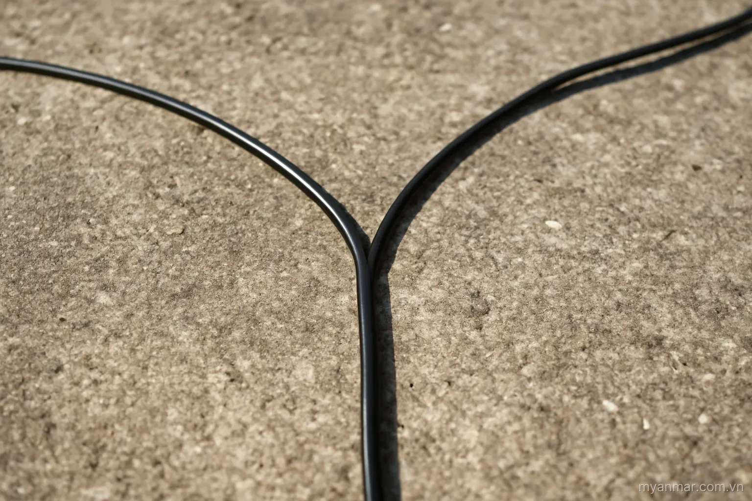 A cord splitting into two paths where one path is thin and unused, overhead view, no text