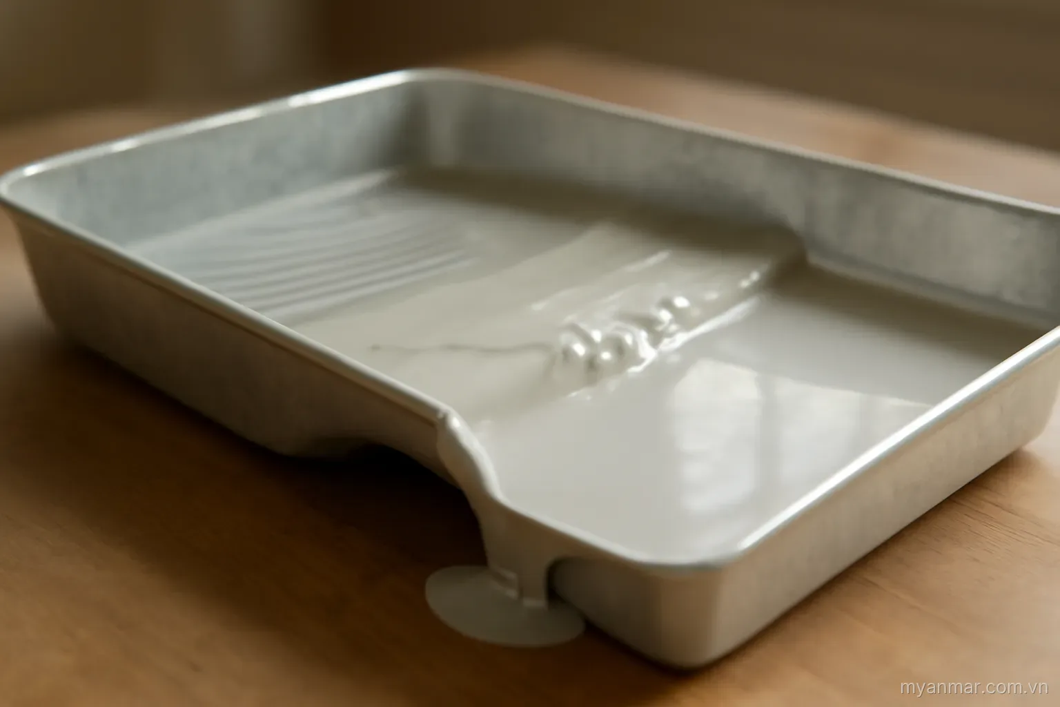A tray where one dividing wall is lower and material has partly flowed across it, side view, no text