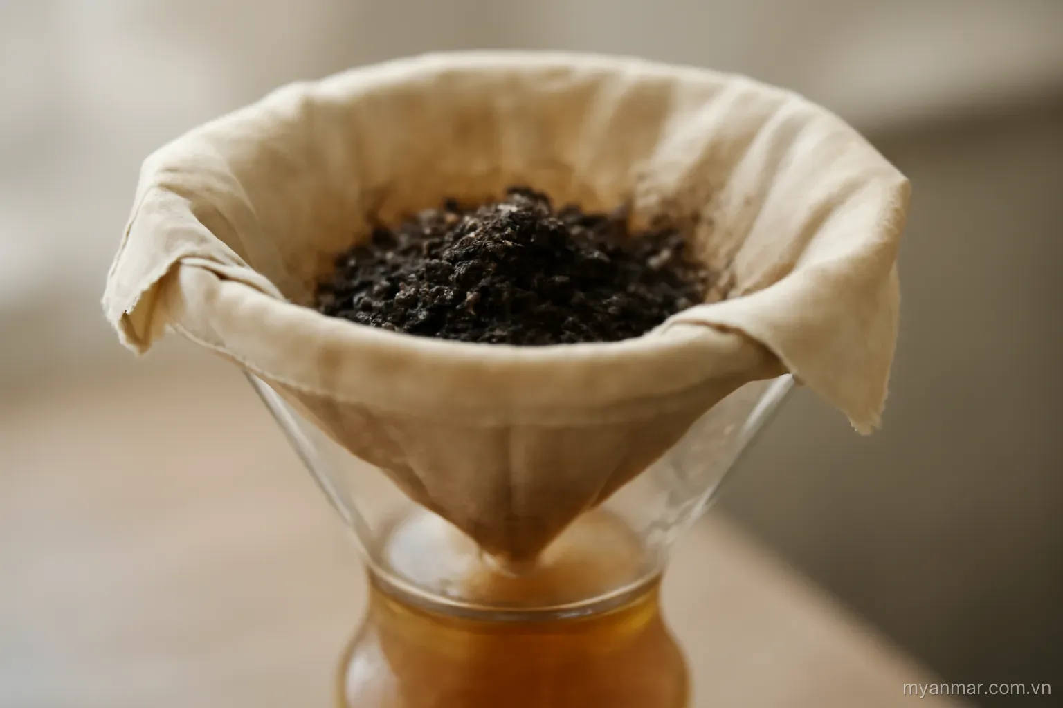 Layered cloth filters in a funnel with sediment caught on the top layer, side view, no text