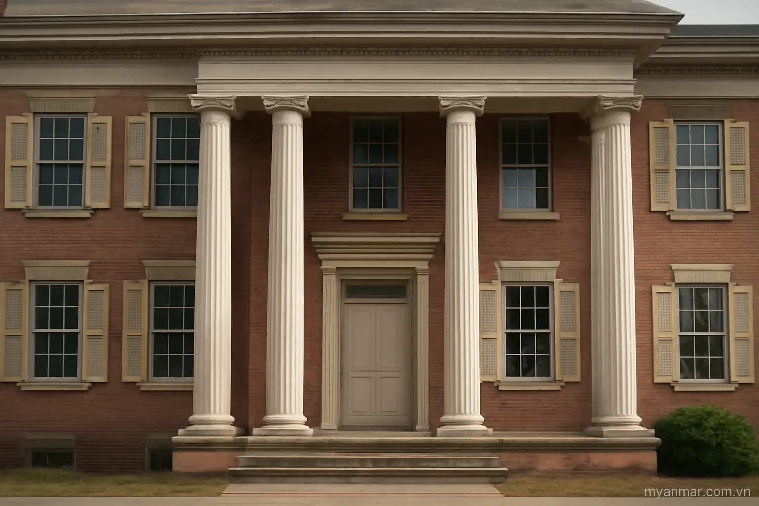 An old brick administrative building with columns and shuttered windows, eye level, no text